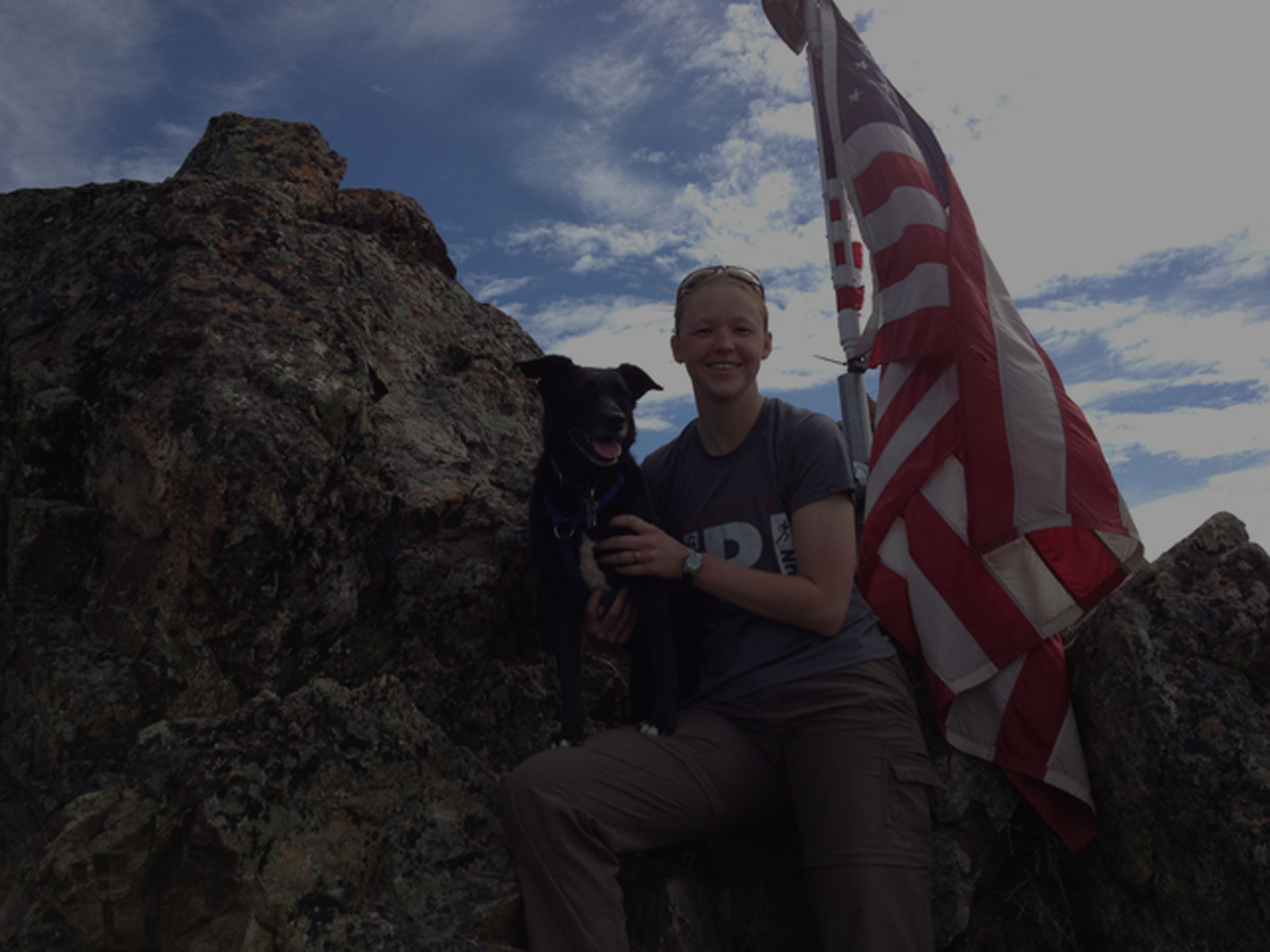 kelly sitted with dog on rock hill